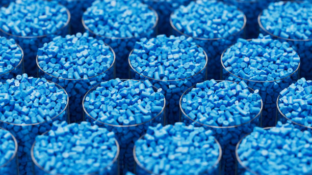 A close-up view of many small blue plastic pellets or beads arranged in rows inside clear cups.